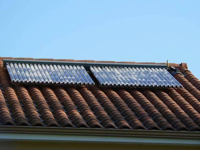 Capteurs solaires thermiques à tubes sous vide installés sur une toiture en tuiles