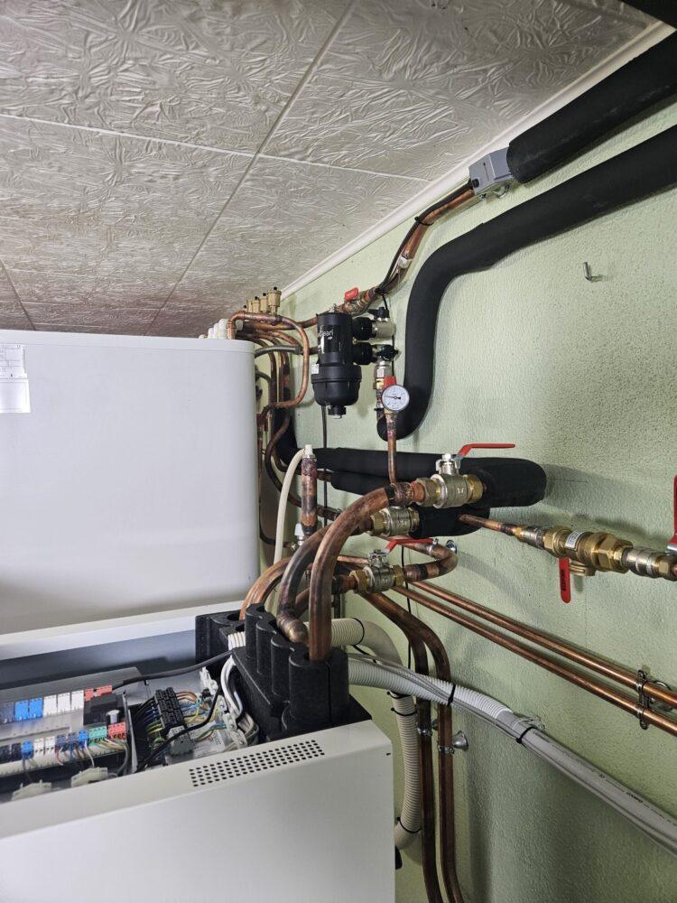 Installation de l'unité intérieure d'une pompe à chaleur avec ses raccordements hydrauliques, vannes et manomètre